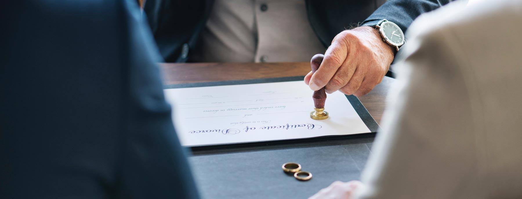 a couple sitting with male lawyer finalizing divorce documents