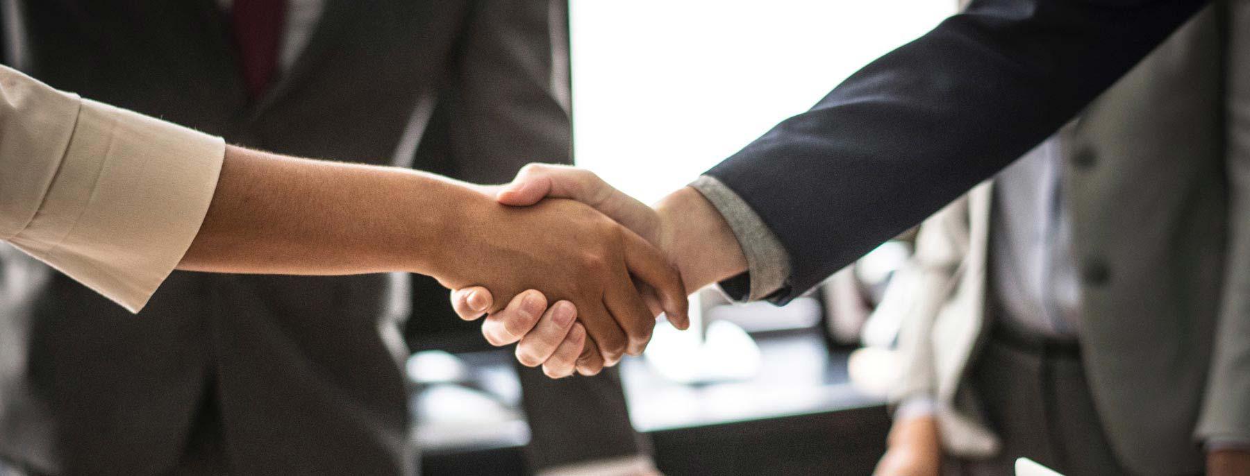a business man and woman shaking hands in agreement